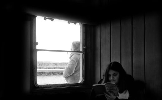 grayscale photo of a woman reading a book