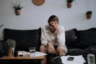 a woman with problems sitting on the sofa