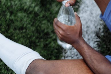 a person opening a bottled water